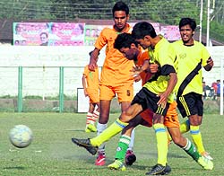 Players vie for the ball in a match during the Nemidas Memorial District Football League at Pavilion Ground in Dehradun on Thursday