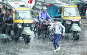 Rain run: A man crosses a road amid rain in Gurgaon on Thursday