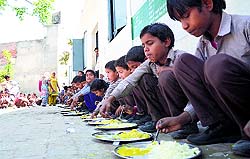 Students of a government primary school partake of mid-day meal
