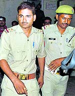 Sub-Inspector Rahul Pandey (L) in police custody in Hamirpur