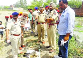 Police personnel inspect the explosives and ammunition recovered from the pond of Sidhwan Khurd village, near Jagraon, on Thursday.