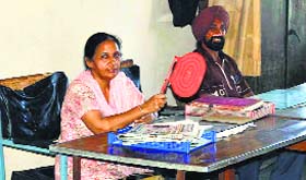 An employee at the Punjab Home Guards and Civil Defence office in Hoshiarpur uses a hand fan.