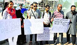 International Forum activists hold a protest against the alleged molestation of a nurse by three officials of the Health Department, in Srinagar on Friday. They also demanded arrest of the Director, Health Service, Kashmir