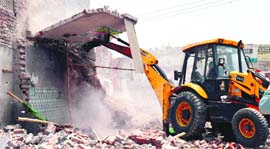 A JCB machine razes the structure at Ghumar Mandi in Ludhiana.