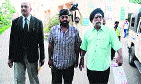 Officials come out of the Kotwali police station in Ludhiana on Friday.