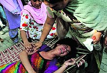 An injured woman cries after she fell down from a police vehicle in Bathinda on Saturday