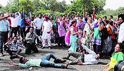 Agitating IEV volunteers block the road during a protest in Bathinda on Saturday
