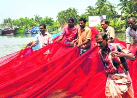 Fishermen gather nets ahead of the 47-day ban on fishing trawlers scheduled to begin from midnight on Saturday
