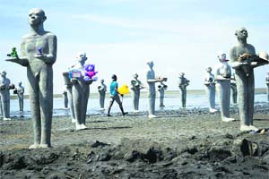 An art installation by Indonesian artist Dada Christanto shows sculptures symbolising victims of the mud volcano disaster erected over the mud-covered Sidoarjo district located in Indonesia’s eastern Java Island on the eighth anniversary of the mud volcano disaster