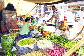 People buy vegetables from a vendor in Hisar
