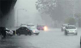 Caught unawares: Vehicles move at a snails pace on a waterlogged road in Gurgaon on Sunday
