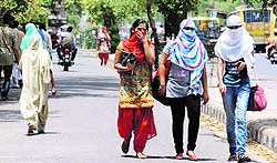 Girls cover their faces to protect themselves from heat in Bathinda on Monday