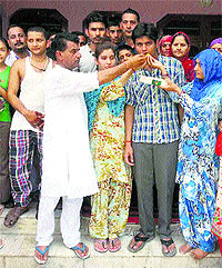 Residents of Kardial village in Jawali subdivison offer sweets to Aman Sharma on Sunday. Photo: Rajiv Mahajan