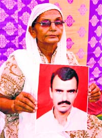 Asha Tuli holds the picture of her bother Yashpal Tuli who went missing in Kedarnath tragedy. 