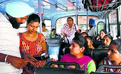 A woman conductor gives tickets to passengers on a PRTC bus in Patiala