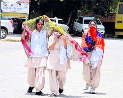 Nursing students cover their faces as they step out of the Civil Hospital in Bathinda