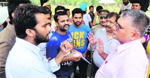 NSUI leaders share a point with a senior official of the Engineering Department regarding poor sewerage facilities, outside the Vice-Chancellors office at Panjab University on Tuesday. 