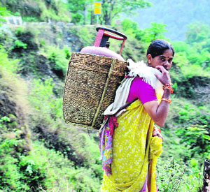 A woman transports an LPG cylinder to her village near Badrinath. Villages affected by the natural disaster in June last year are facing an acute shortage of gas cylinders.