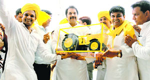 HJC chief Kuldip Bishnoi is presented the model of a tractor, the partys symbol, during a rally at Assandh in Karnal district on Tuesday.