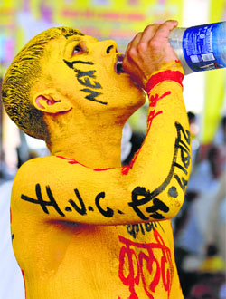 Die-hard HJC supporter Sandip Gautam quenches his thirst during the rally.