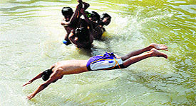 Chldren enjoy in a canal to stay cool near Jalandhar on Tuesday