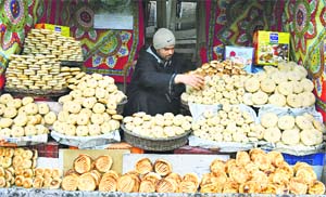 A Kashmiri sells bread and other baked products at his shop near Srinagar on Tuesday.