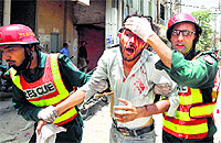 Rescue workers assist an injured supporter of Tahirul Qadri, a Sufi cleric and leader of political party Pakistan Awami Tehreek, during a protest in Lahore on Tuesday.