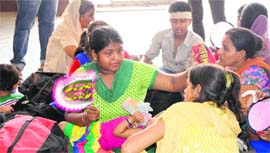 Railway passengers fan themselves at Amritsar railway station on Wednesday.