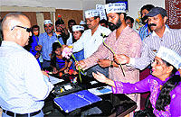 Aam Aadmi Party workers present flowers to an Irrigation Department official in Dehradun on Wednesday. 