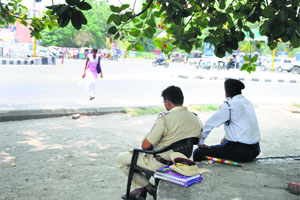 Traffic cops sit under the shade of a tree to protect themselves from scorching heat in Ludhiana.