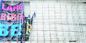 Workers put up a hoarding outside Pavilion Mall without safety equipment in Ludhiana. 