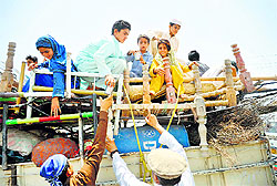 Pakistani civilians, fleeing from a military operation in North Waziristan tribal agency, arrive in Bannu district on Wednesday. Pakistan eased curfew in a tribal area to allow civilians to flee a major offensive against the Taliban.