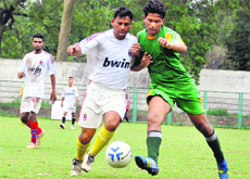 Players vie for the ball during the district-level football tournament at Pavilion Ground in Dehradun on Thursday.