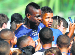 Italys Mario Balotelli (C) poses for a selfie with children during a training session in Mangaratiba.