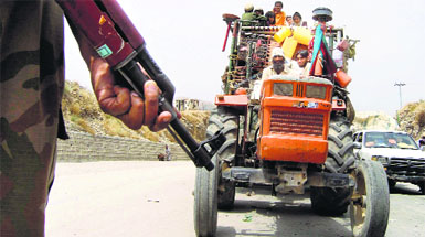 A soldier stands guard as a tractor carrying refugees fleeing the military offensive against the Pakistani militants in North Waziristan, drives past a checkpoint in Bannu, located in Pakistans Khyber-Pakhtunkhwa province on Thursday.