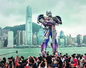 A 20 foot-tall Optimus Prime figure is surrounded by journalists before the world premiere of Hollywood movie Transformers 4 in Hong Kong on Thursday. 