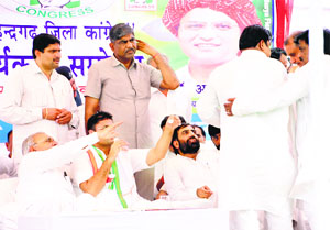 Congress leaders take a party leader away from the dais after he entered into an argument with Chief Minister Bhupinder Hooda during a meeting in Narnaul on Friday.
