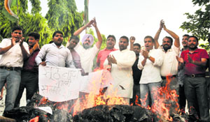 Members of the Youth Congress burn effigies of Prime Minister Narendra Modi and Railway Minister Sadananda Gowda to protest the increase in rail fare at the Chandigarh Congress Bhawan, Sector 35, Chandigarh, on Saturday.