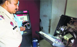 A policeman inspects the broken ATM at Kurali on Saturday. 