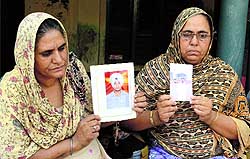 Mothers of Punjabi youths stuck in Iraq, with the photographs of their sons