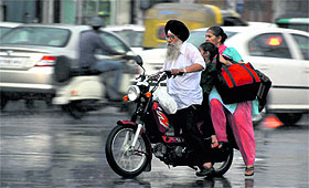 Commuters caught in the rain in Ludhiana on Saturday evening.