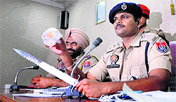 ACP J Elanchezhian shows a weapon and a gold ring recovered form snatchers in Ludhiana. 