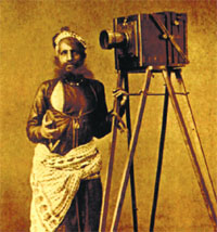 Unidentified Photographer standing by his camera.
