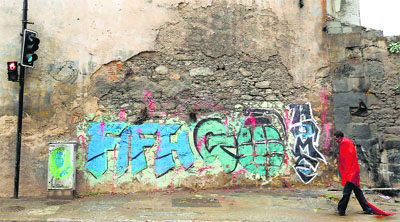 A homeless man walks past graffiti that reads "FIFA go home" in Rio de Janeiro. Rio de Janeiro is one of the host cities for the 2014 World Cup in Brazil.