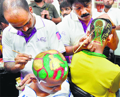 Football fans paint their heads to support their favourite teams for the FIFA World Cup 2014, in Mumbai.