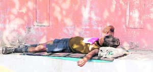 A homeless person sleeps on the footpath in Amritsar.