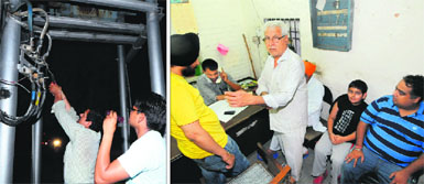 (Left) Electricity Department employees repair a line with the help of a small torch at Sector 21, Chandigarh; and (right) Residents from various parts of the city wait for their turn to register their electricity complaint at 11.30 pm in Sector 20.