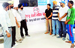SMO Jasvir Singh interacts with customers of a bank during a drive against drug addiction in Dehlon.