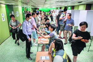 Volunteers vote at a polling station in Hong Kong on Sunday. Hong Kong citizens cast their ballots in an unofficial referendum on democratic reform.