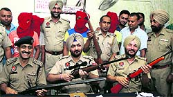 Police officials show weapons recovered from the contract killers gang in Jalandhar on Monday.
